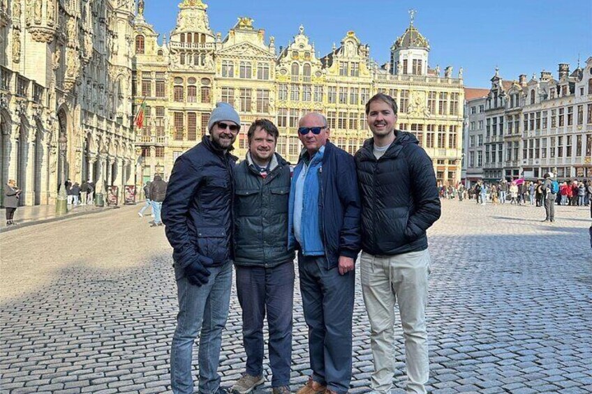 Four people standing in front of a historic building with intricate architecture. 4