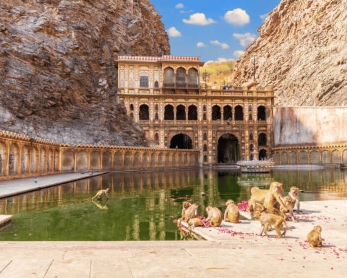 A historic building with arches and a reflection pool. 2