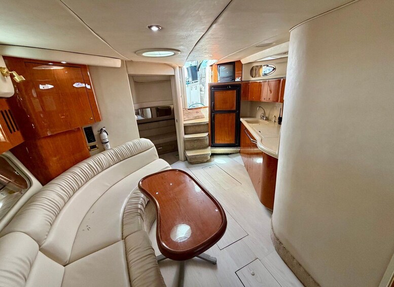 A compact kitchen with a sofa, a wooden table, and a small TV. 5