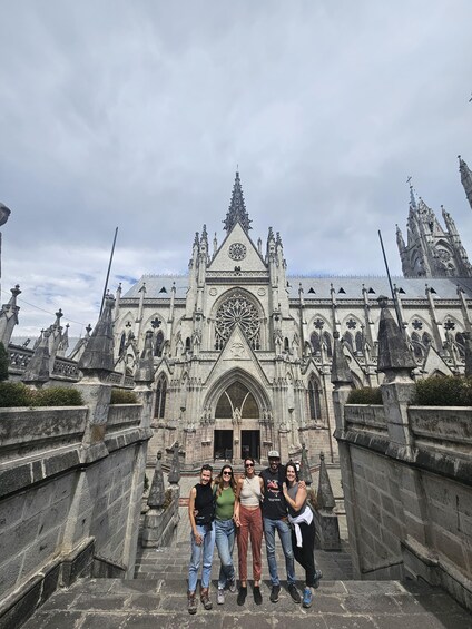 A group of people standing in front of a Gothic-style cathedral with intricate architecture and statues. 4