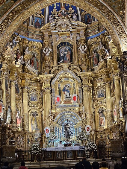 An ornate religious altar with intricate gold detailing and statues. 2