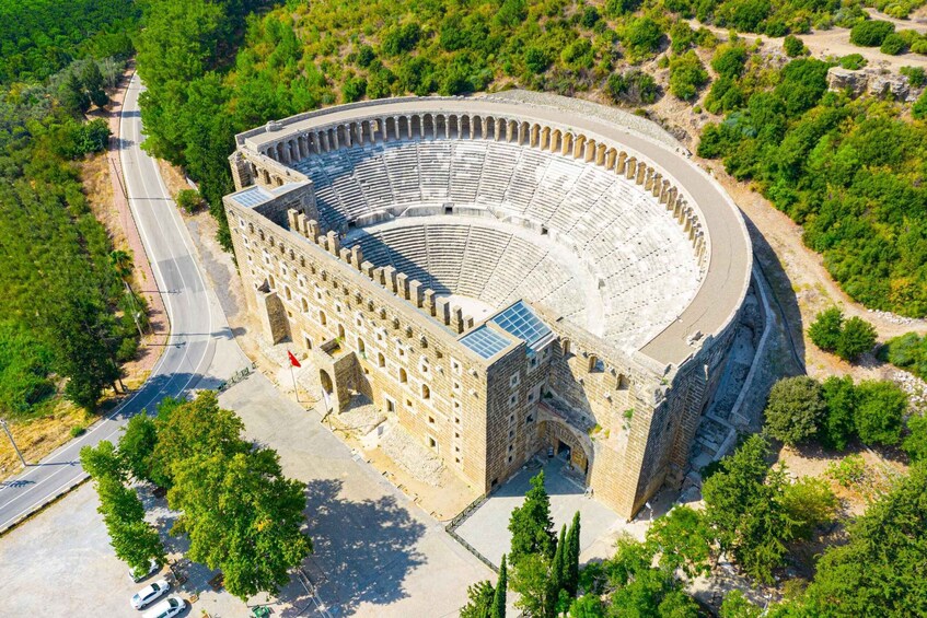 An ancient amphitheater surrounded by greenery. 5