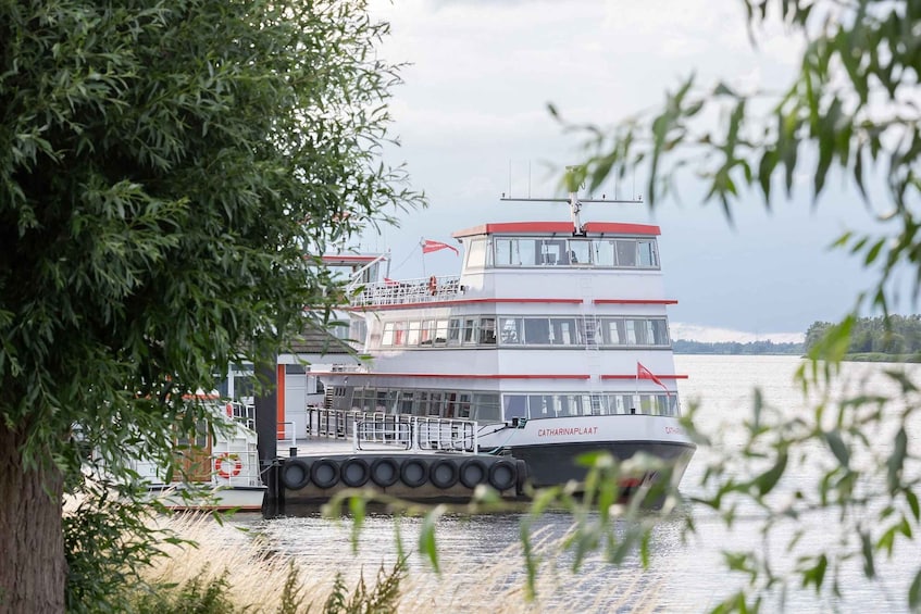 A multi-deck boat named Catharinenplaat docked at a pier with a red flag on top. 3