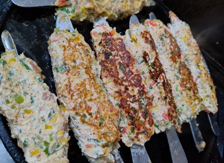 Grilled patties with visible herbs and vegetables. 2