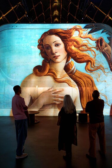 Un mural grande con una mujer y un niño, gente observándolo. 4