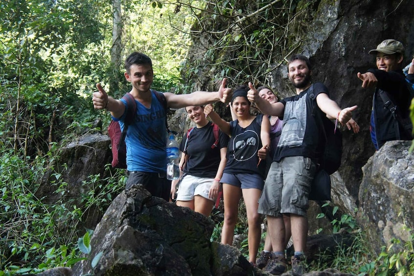 A group of hikers on a rocky trail surrounded by dense forest. 2