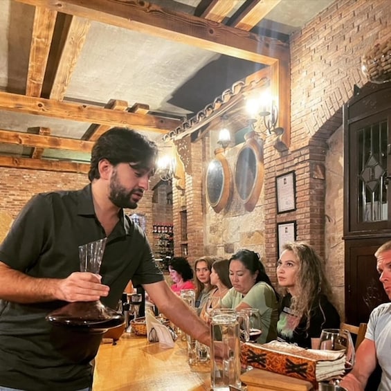 L’intérieur d’un restaurant, avec des murs en briques, des poutres en bois et des clients qui déjeunent ou dînent. 1