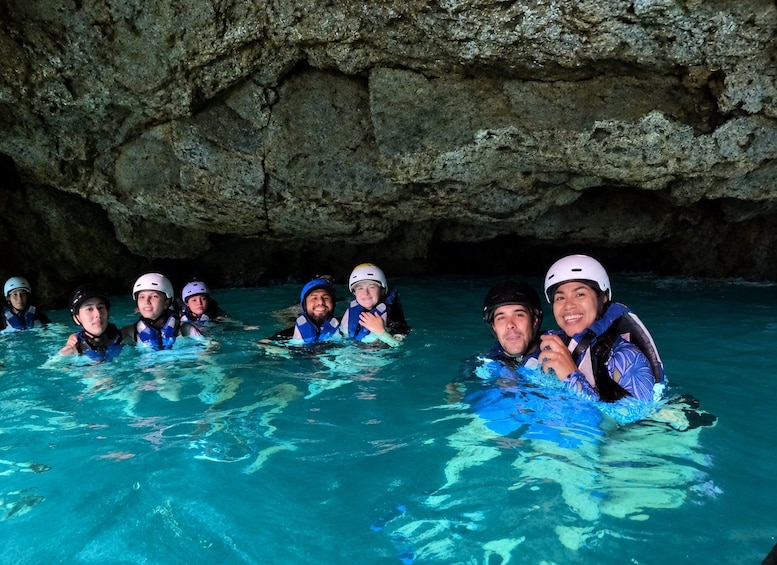 A group of people in a cave with water. 4