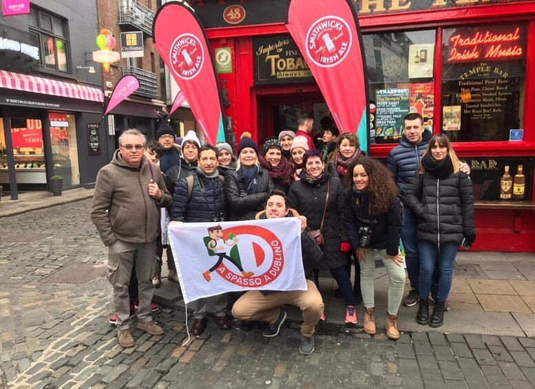 A group of people holding a banner in front of a pub. 4