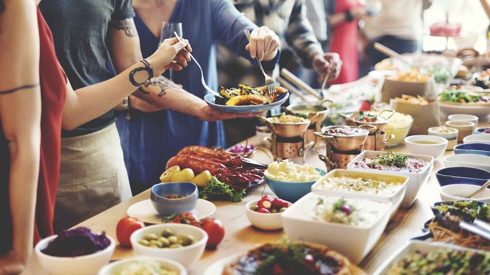 A buffet table with various dishes, including roasted meats, salads, and side dishes. 2