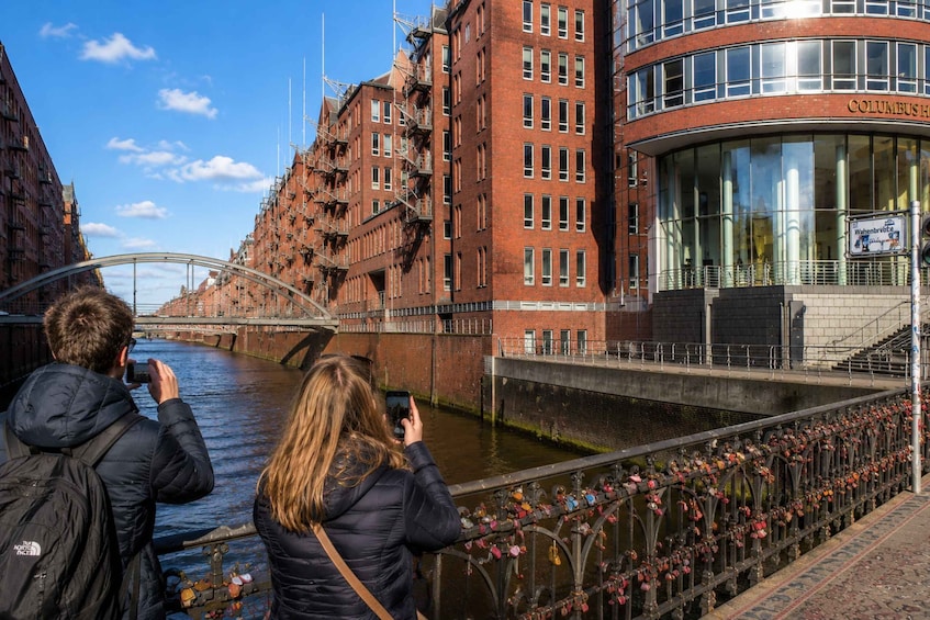 A river with a bridge, a building with a sign reading 'Columbus House,' and a decorated railing. 5