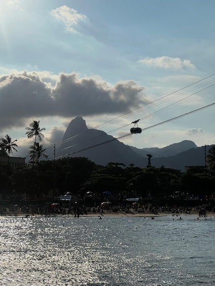 A cable car over a beach with palm trees and mountains in the background. 5