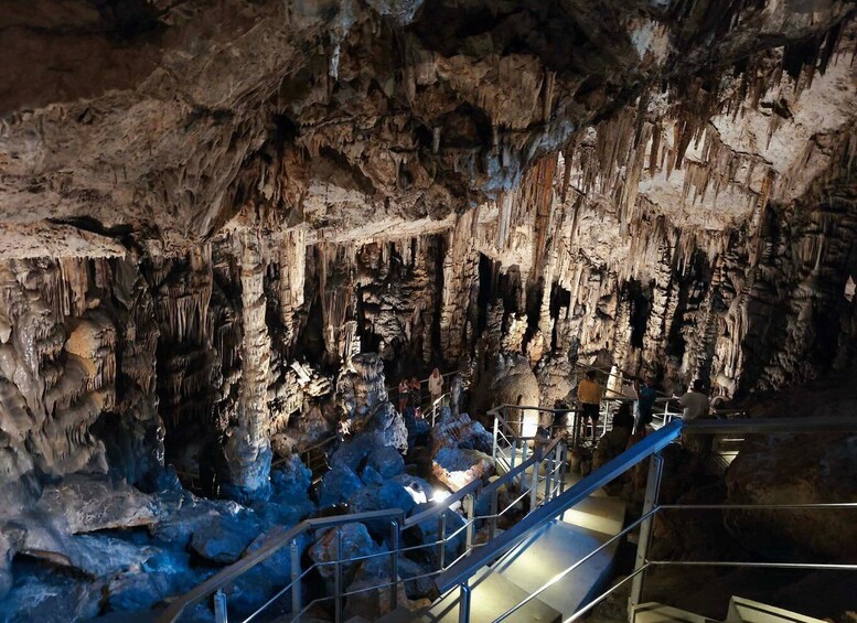 En hule med stalaktitter og stalagmitter, en metal trappe og besøgende. 2