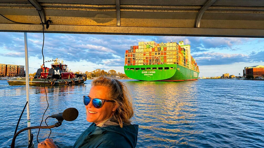 A person on a boat with a large green cargo ship labeled 'EVER LIVING SINGAPORE' in the background. 2