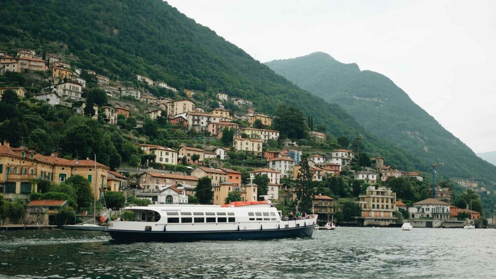 A boat on a lake with a hillside of colorful buildings in the background. 2