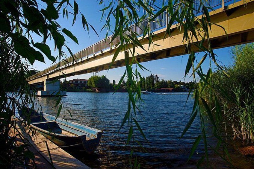 Un río con barcos, un puente y vegetación. 2