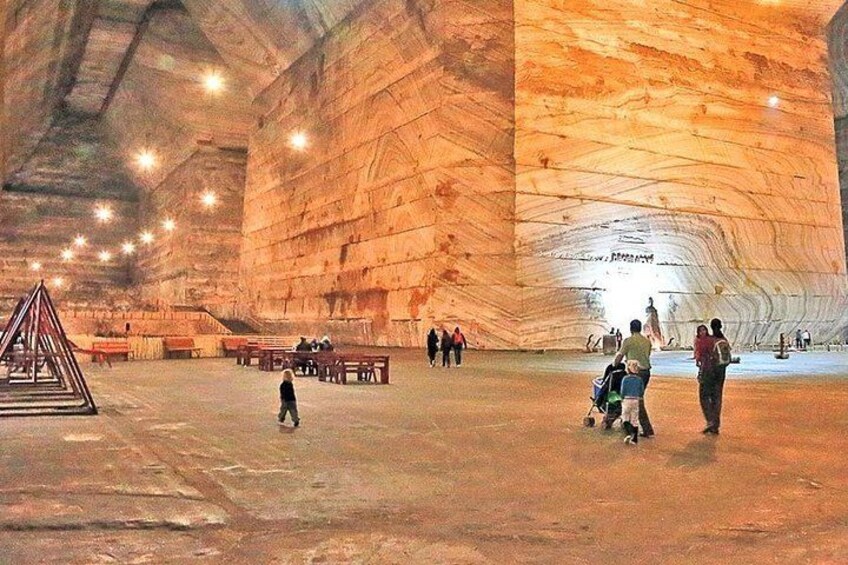 Una cueva extensa con un techo alto y una pared rocosa destacada. 1