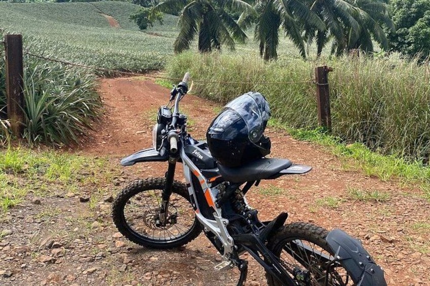 A dirt path with a motorcycle parked on the side. 3