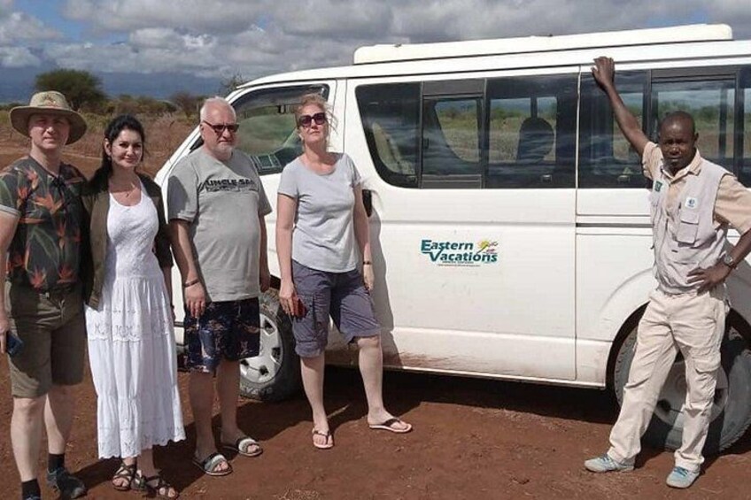 A group of people standing in front of a vehicle with the text 'Eastern Vacations' on it. 1