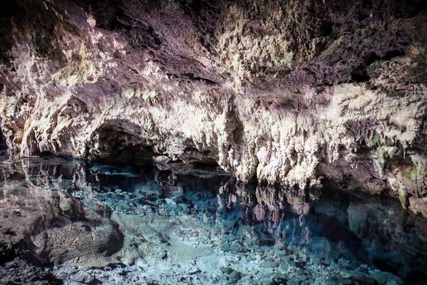 A cave with clear blue water and rocky formations. 2