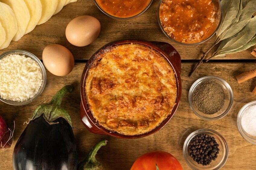 A baked dish in a ceramic dish surrounded by ingredients like eggs, tomatoes, and spices. 5