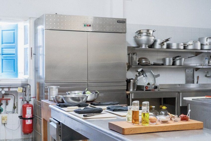 A commercial kitchen with stainless steel appliances, a fire extinguisher, and various cooking utensils. 2