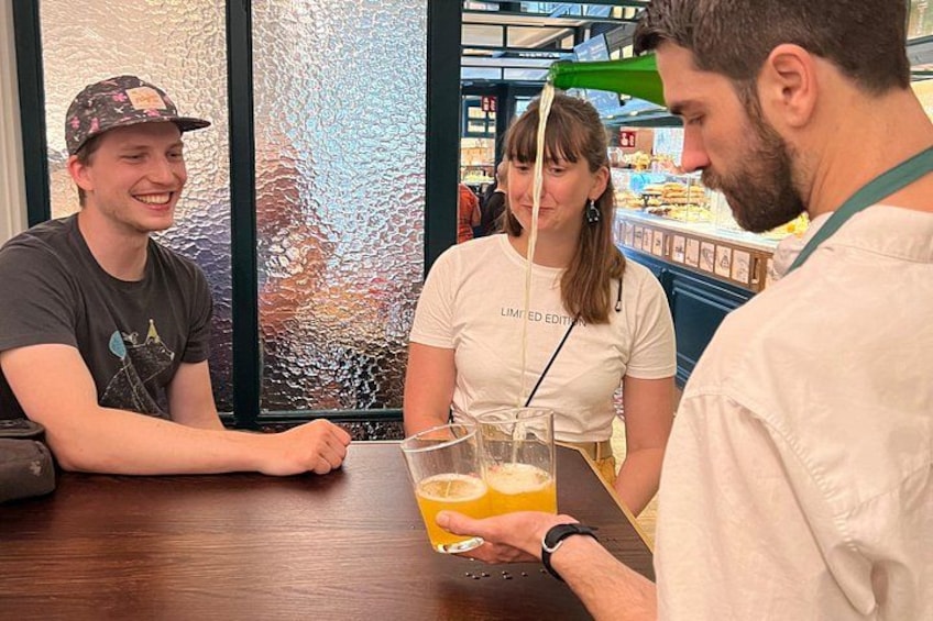 Drie personen zitten aan een tafel, voor hen staat een drankje. 3