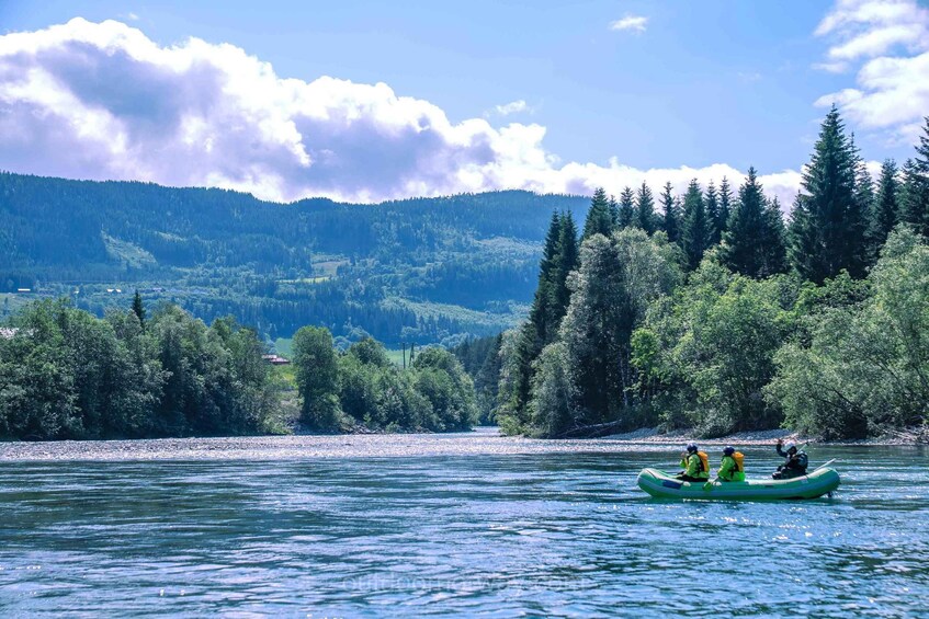A river with three people kayaking. 1