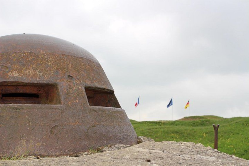 A rusted dome structure with flags in the background. 1