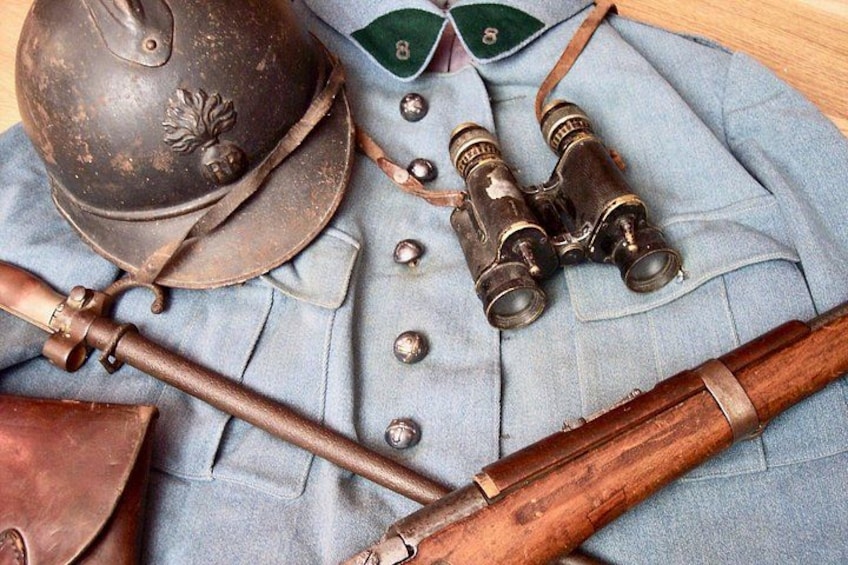 En militäruniform, en hjälm, en kikare och ett gevär. 5