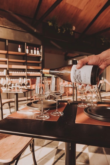 Una mano che versa vino in calici su un tavolo in un ristorante. 1