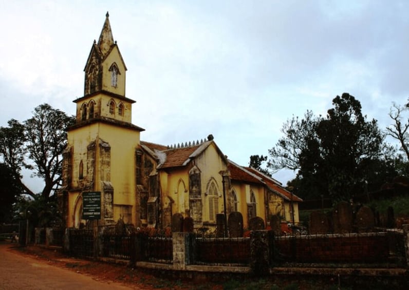 An old church with a bell tower and a cemetery in front. 5