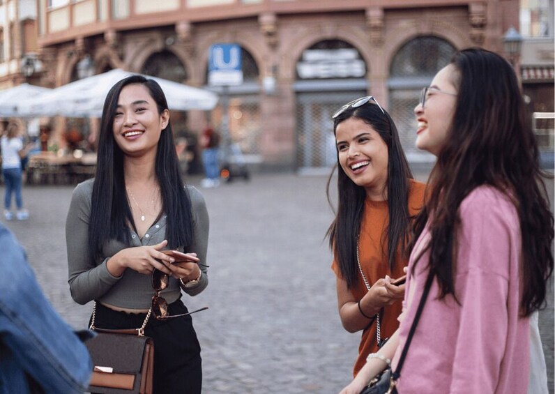 Un grupo de mujeres conversando en una calle adoquinada en una zona urbana con edificios históricos al fondo. 5