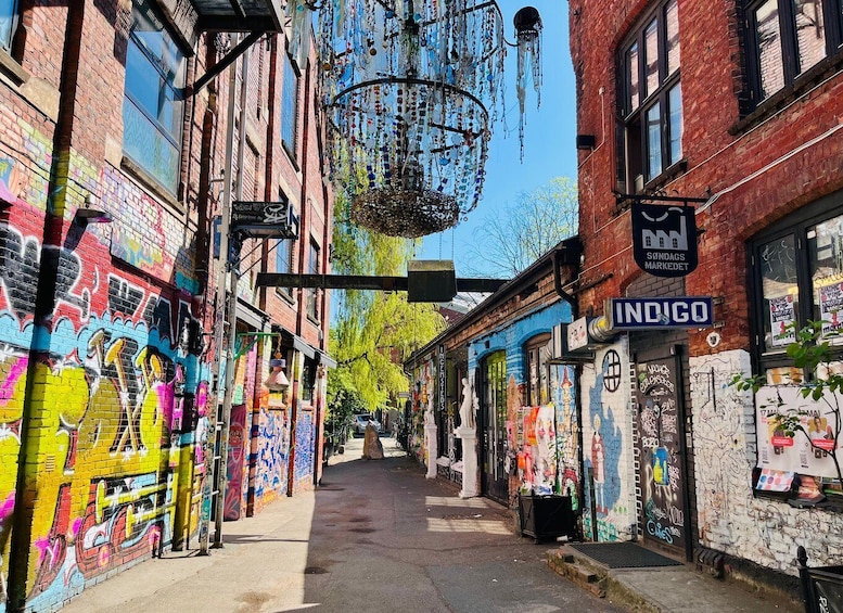 A narrow alley with colorful graffiti, a hanging light fixture, and a sign for 'INDIGO.' 4