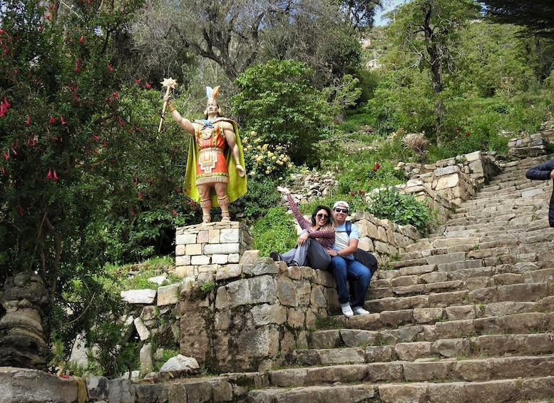 Una statua di un guerriero su una scala di pietra circondata dal verde. 1