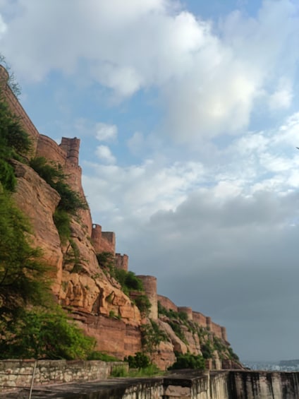 A rocky cliff with ancient ruins and a stone bridge. 3
