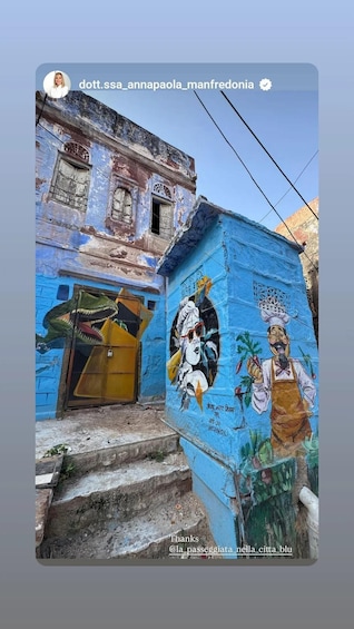 A building with a blue facade and a mural of a man with a crown and a woman. 5