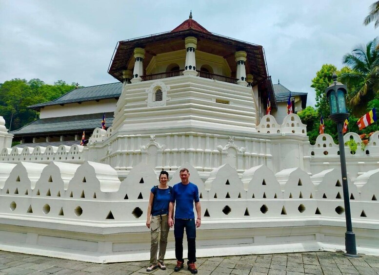 Ein weißer Tempel mit rotem Dach, umgeben von einem weißen Zaun mit dreiecklichen Mustern. 2