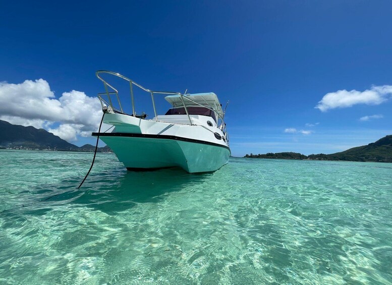 A boat on clear turquoise water with mountains in the background. 4