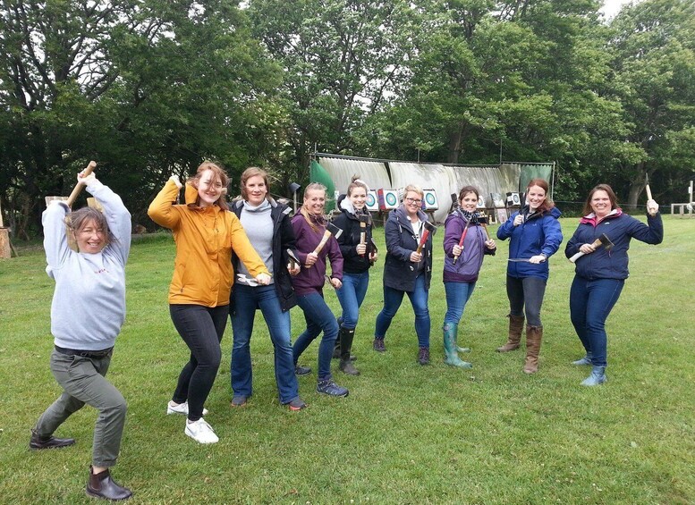 A group of people in a grassy field with trees in the background. 3