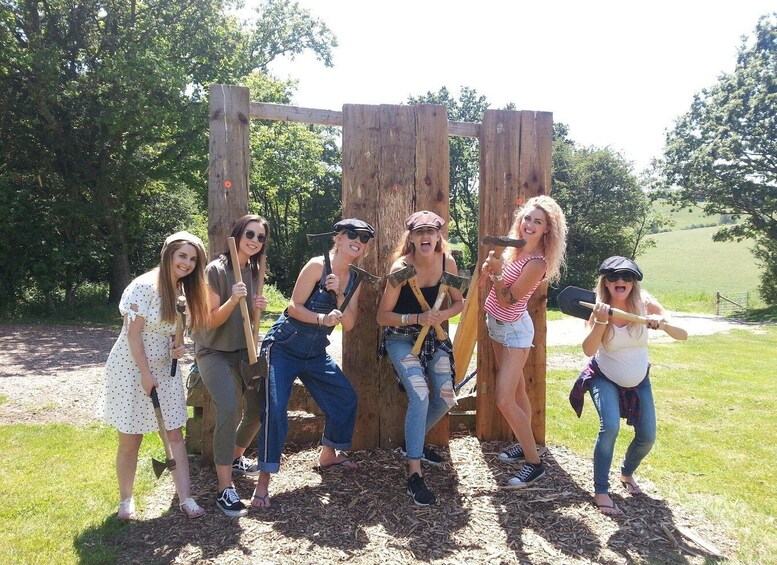 A group of people posing with tools in a wooded area. 5
