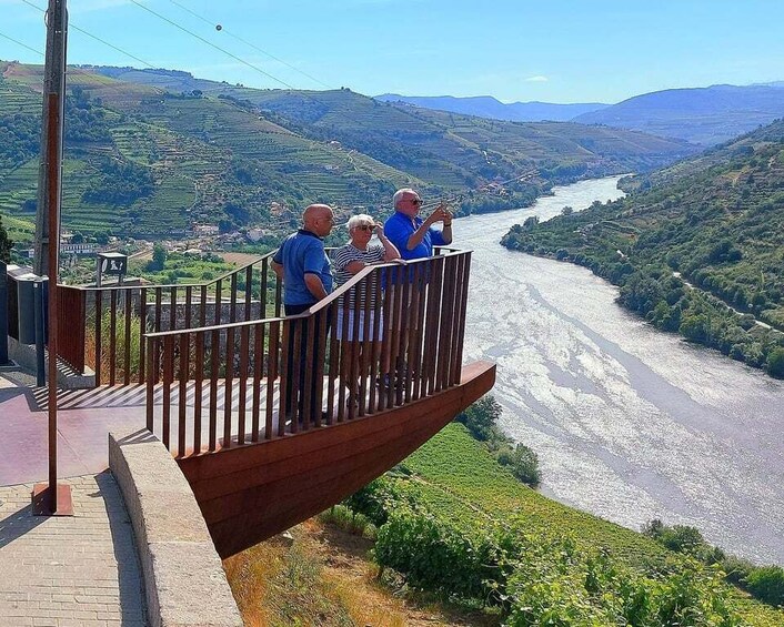 A wooden viewing platform overlooking a river valley with terraced fields. 2