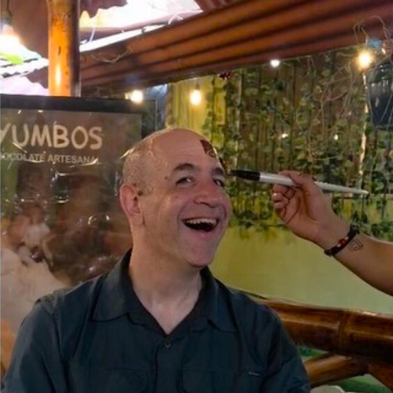 A person holding a pen near a sign that reads 'YUMBOS CHOCOLATE ARTESANA.' 2