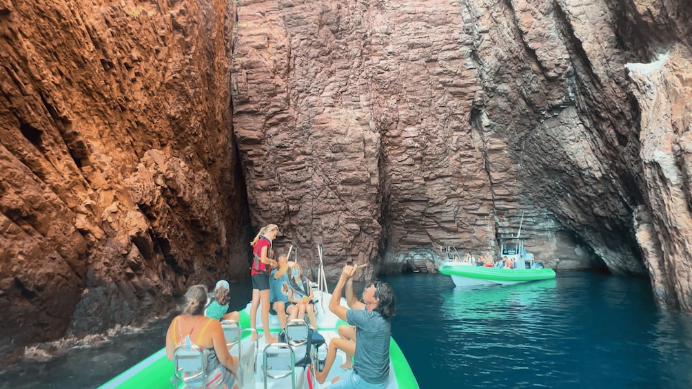 En gruppe mennesker på en båd i en grotte med klippevægge. 3