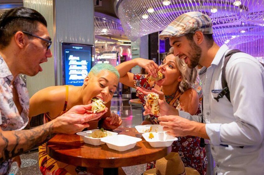 A group of people dining at a restaurant with a modern interior and a digital menu display. 2