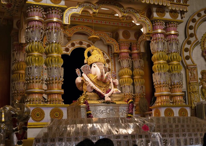 A large, ornate statue of Ganesha in a temple setting. 3