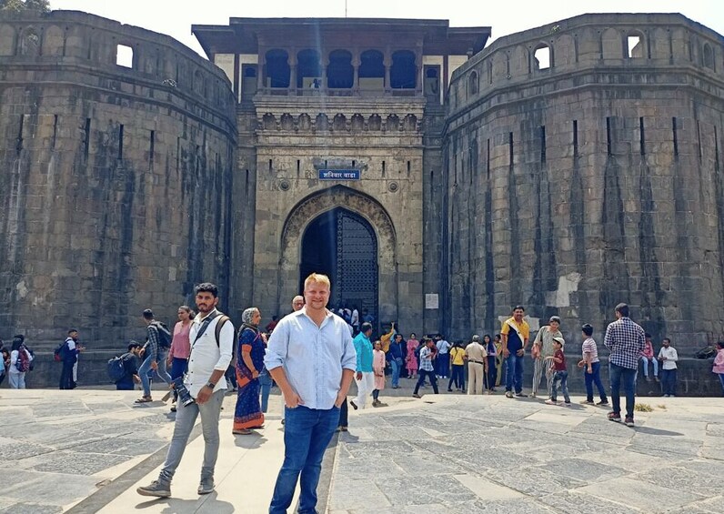 A large stone gate with inscriptions, surrounded by a crowd of people. 2