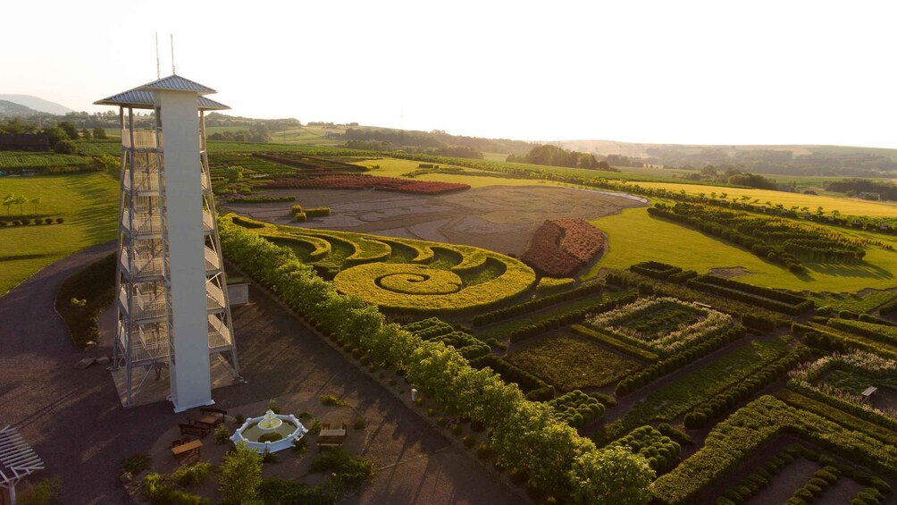 A landscaped garden with geometric patterns, a tower, and a fountain. 5