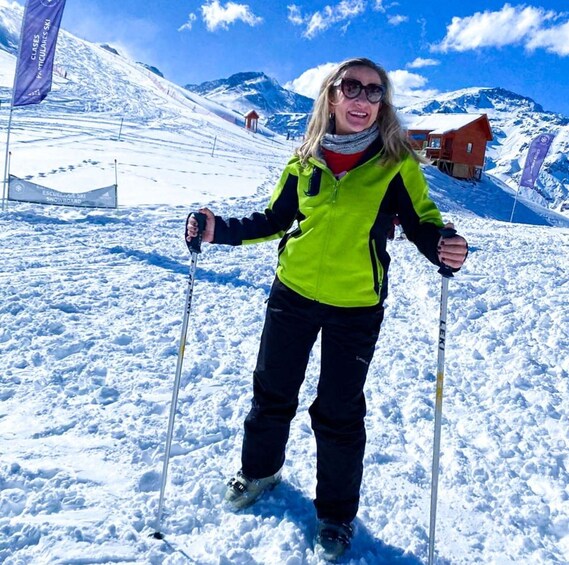 A person skiing on a snowy slope with flags and a ski lift in the background. 5