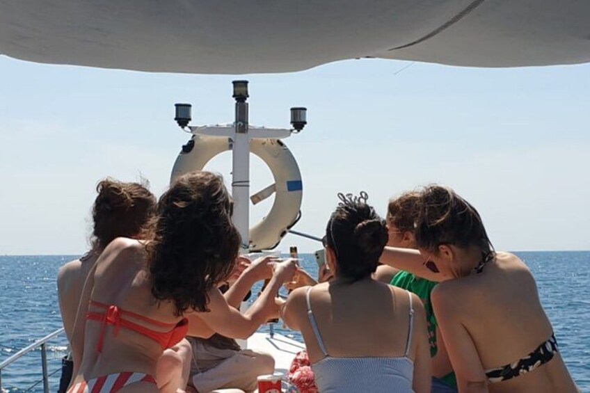 Un groupe de personnes à bord d’un bateau, une bouée de sauvetage et l’océan. 1